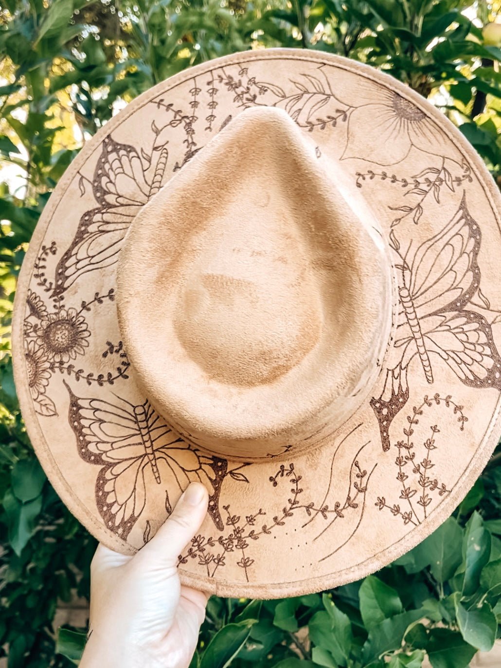 Boho hat with large floral and butterfly design on brim and crown shown in light tan
