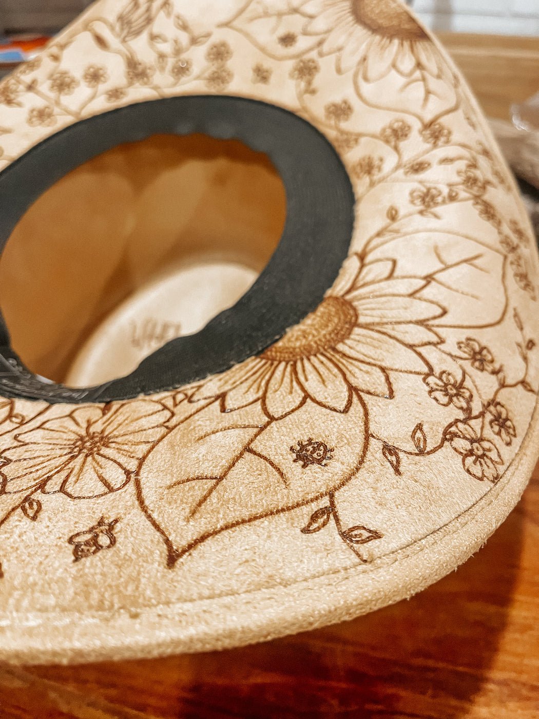 Cowgirl hat with hand-drawn wildflowers, butterflies, bees, and dragonflies around brim. Sunflower and poppy detail.