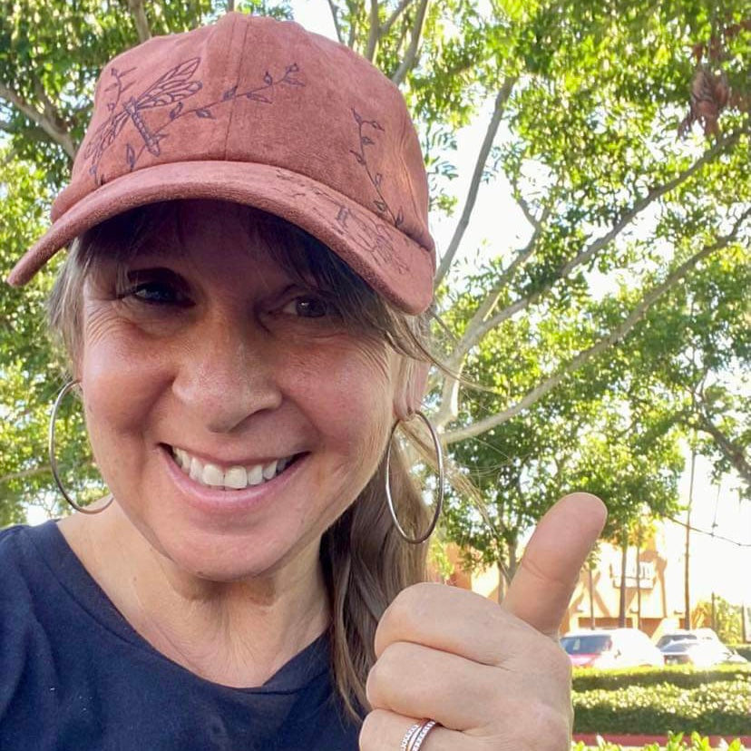Customer photo of woman wearing dragonfly baseball hat in dark tan