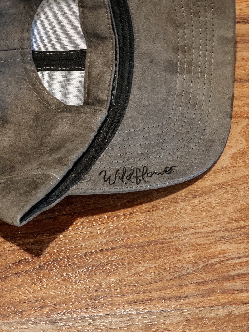 Baseball hat with hand-drawn mountains, fir trees, and a dandelion on the bill
