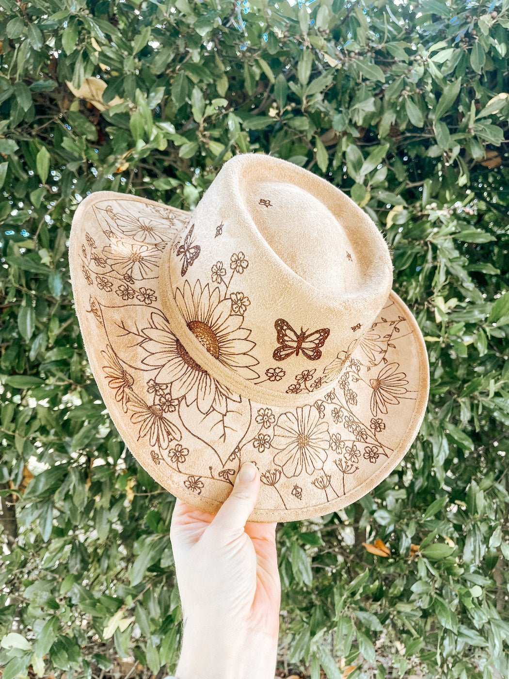Cowgirl hat with hand-drawn wildflowers, butterflies, bees, and dragonflies around brim