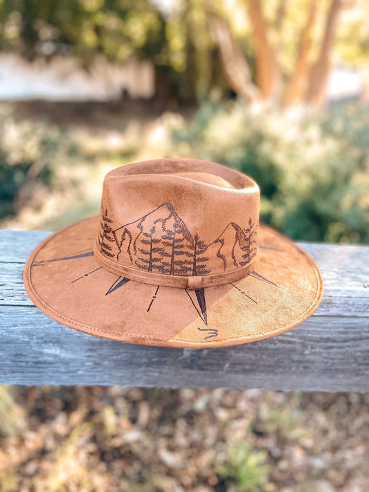 Dark tan fedora with hand-drawn compass and mountain design on crown