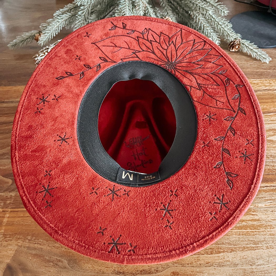 Red fedora with hand-drawn poinsettia, sparkle illustrations, and winter vines