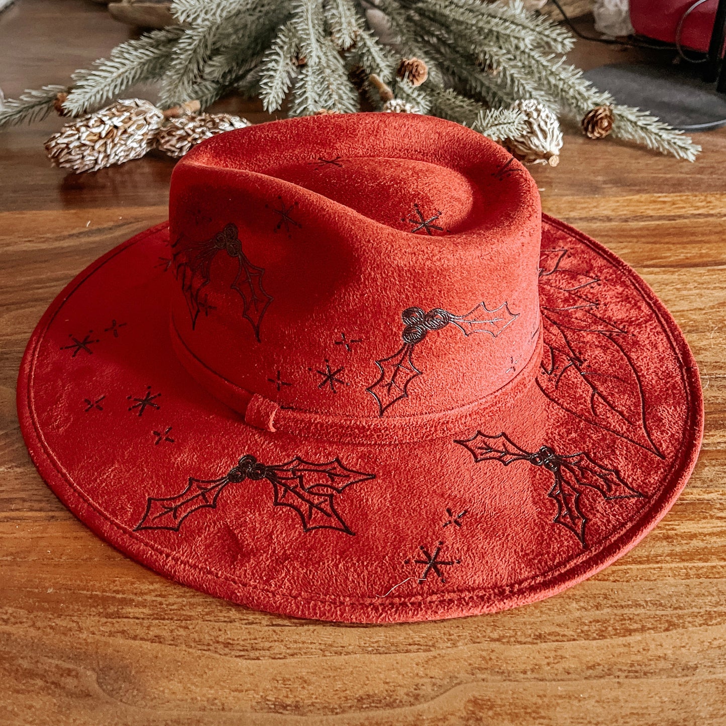 Red fedora with hand-drawn poinsettia, sparkle illustrations, and winter vines