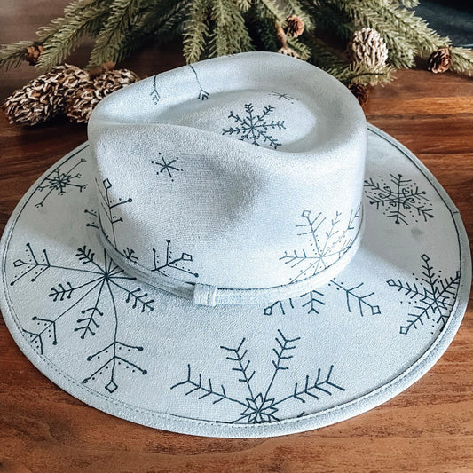 Light blue fedora with hand-drawn snowflakes on top and bottom brims