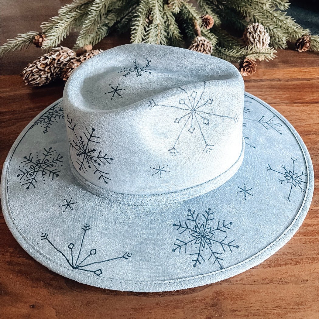 Light blue fedora with hand-drawn snowflakes on top and bottom brims